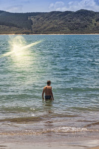 Rear view of man in sea