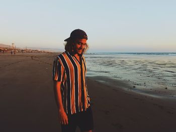 Man walking at beach against sky