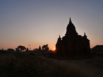 Silhouette of temple building against sky during sunset