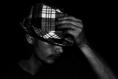 Close-up portrait of young man against black background