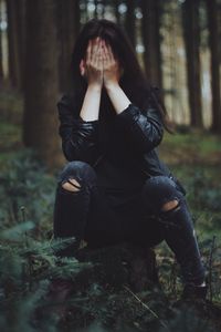 Young woman sitting in forest