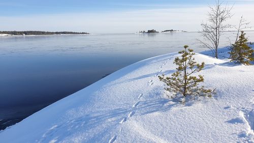 Scenic view of snow covered land against sky