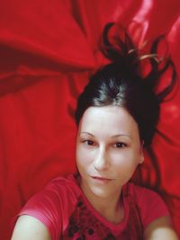 Portrait of beautiful young woman lying on bed