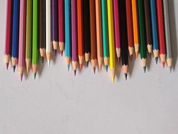 High angle view of colored pencils in row