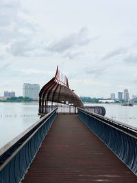 Footbridge over river with buildings in background