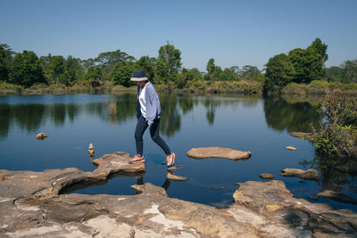 Rear view of man with arms raised in lake