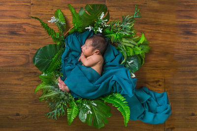 High angle view of girl sleeping on wooden floor