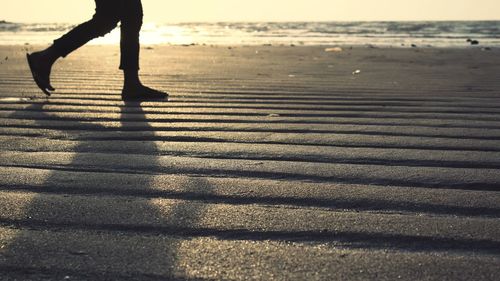 Low section of woman walking on beach