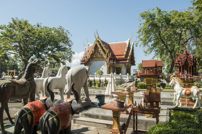 Statues against trees and temple against sky