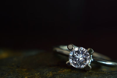 Close-up of diamond ring against black background