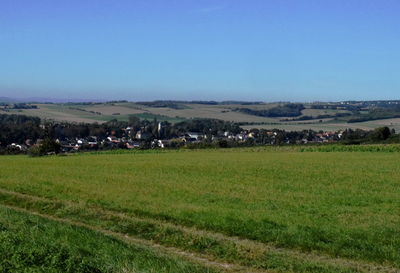 Scenic view of field against clear blue sky