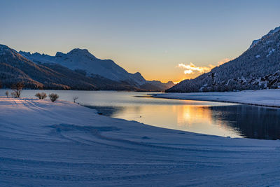 View of beautiful sunet at lake silvaplana, switzerland, in cold winter evening with foreground snow
