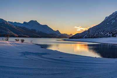 Scenic view of frozen lake against sky during sunset