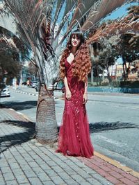 Portrait of young woman standing on street in city