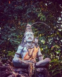 Statue of buddha against trees