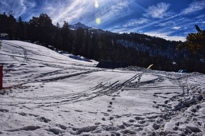 Snow covered land against sky