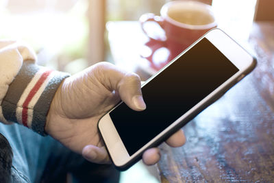 Close-up of hand holding mobile phone