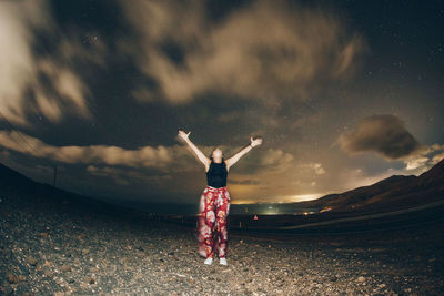 Rear view of woman standing on rock