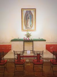 Table and chairs against wall in building