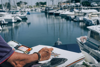 Cropped image of man painting harbor