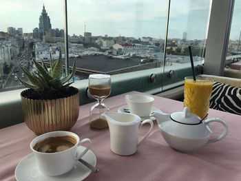 Cup of coffee and cups on table in city