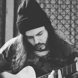 Young man plying guitar at home