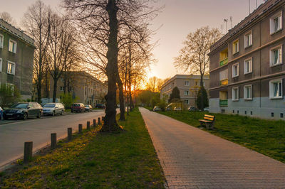 Street amidst buildings against sky during sunset