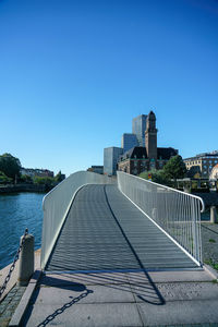 Bridge over river against clear blue sky