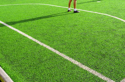 Low section of woman standing on soccer field