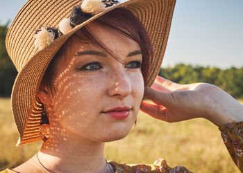 Close-up portrait of young woman with hat