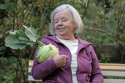 Mid adult woman holding cabbage outdoors