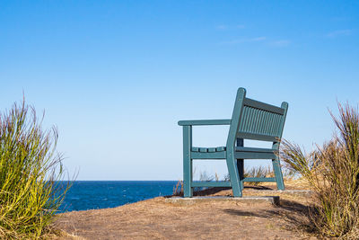 Lifeguard hut on beach against clear blue sky