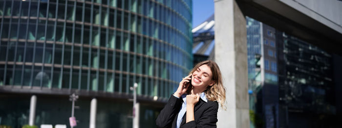 Portrait of young woman standing in city