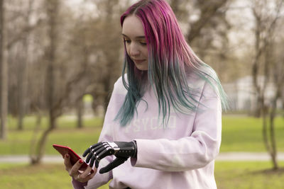 Young woman with amputated hand using smart phone