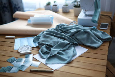 Sewing machine, paper patterns and cloth on desktop in workshop. concept small sewing business 