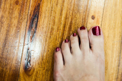 Low section of woman legs on wooden floor