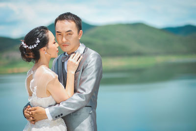 Young couple standing by lake