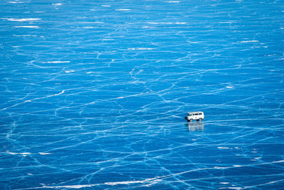 Aerial view of van driving on frozen lake