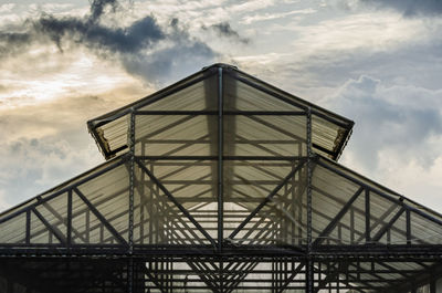 The structure of greenhouse roof is made of steel frames. sky background.