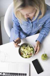 High angle view of businesswoman while eating food at home