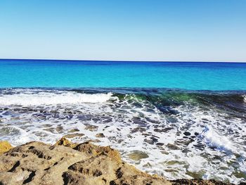 Scenic view of sea against clear blue sky