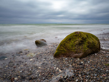 Scenic view of rocks on beach against sky