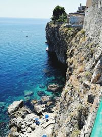 Aerial view of rocks by sea against sky