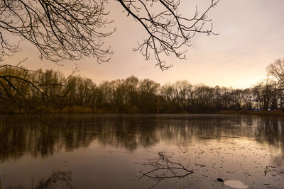 Scenic view of lake against sky at sunset