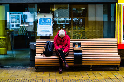 Full length of woman sitting on bench