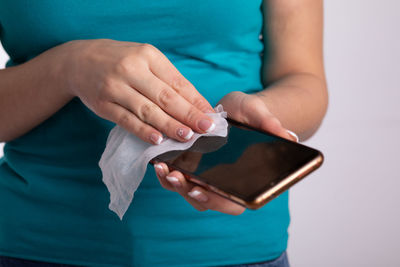 Midsection of woman holding smart phone