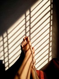 Low section of woman by wall at home