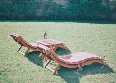 Deck chairs on field by trees