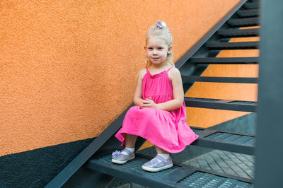 Low angle view of young woman standing against wall