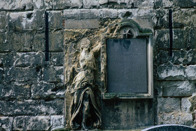 Close-up of old sculpture against wall